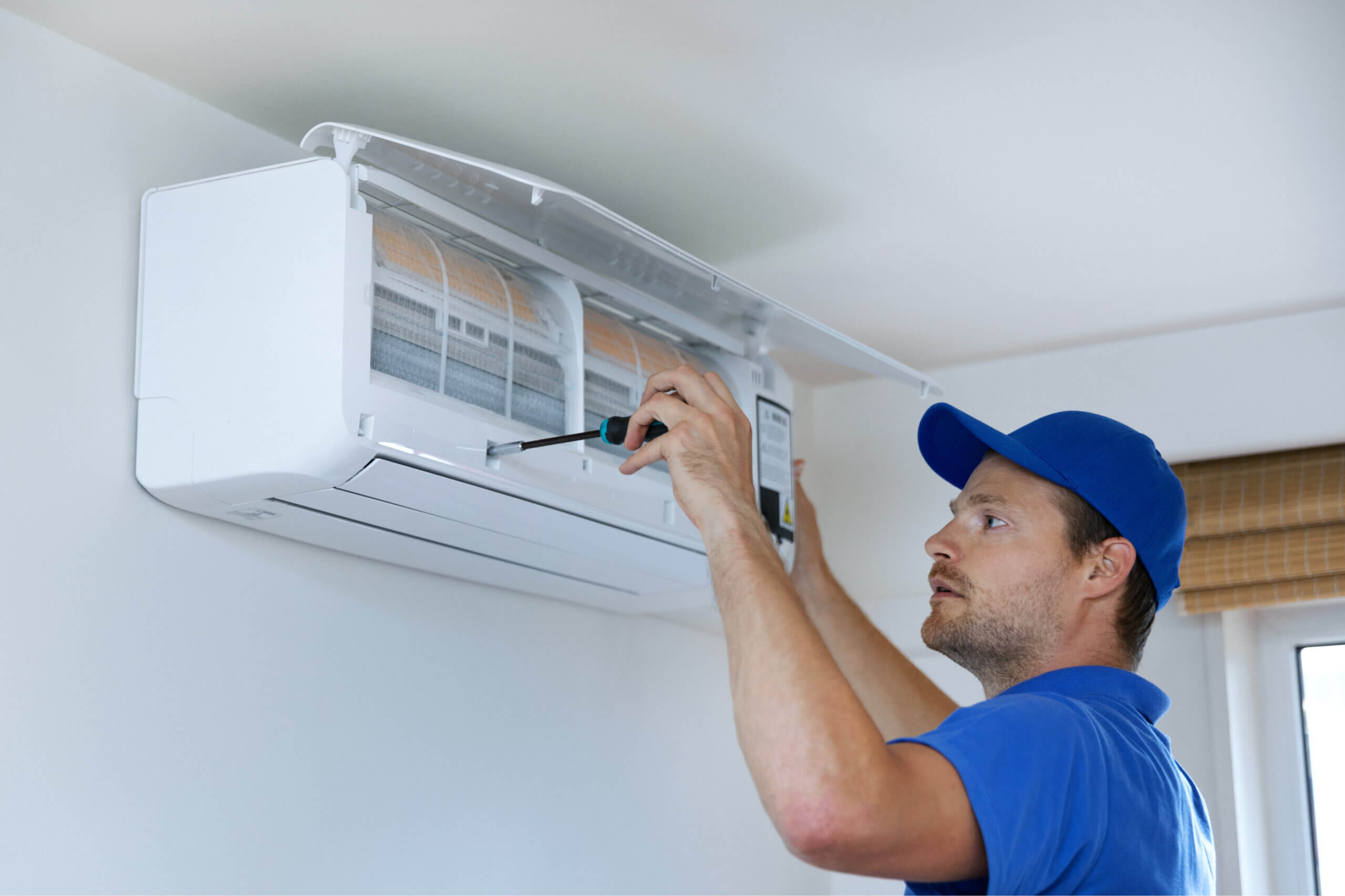 shutterstock_1787389469_optimized Tech providing maintenance for a ductless unit