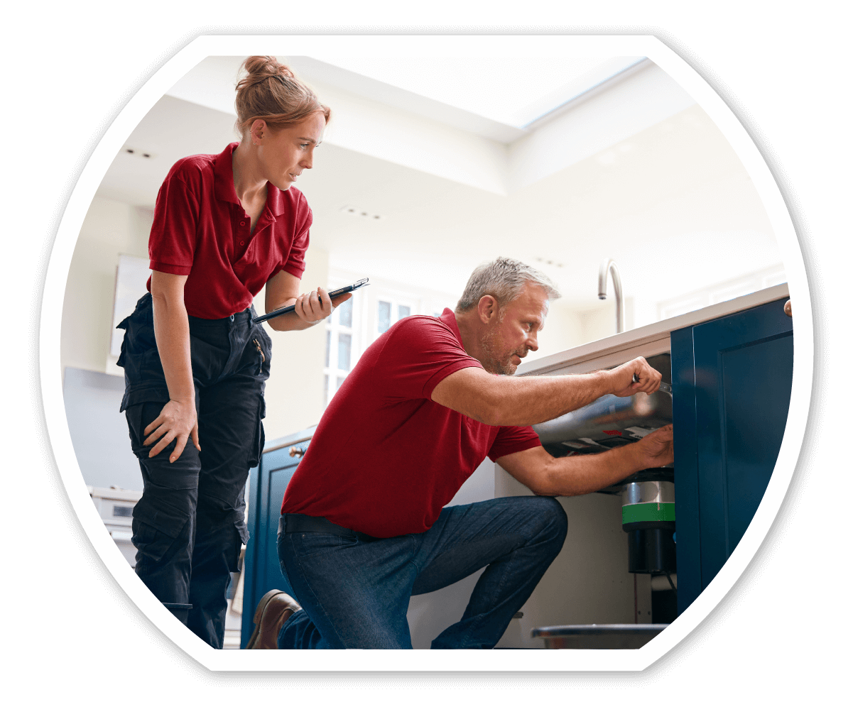 Two Goodco plumbing experts working together to inspect and service a kitchen sink.