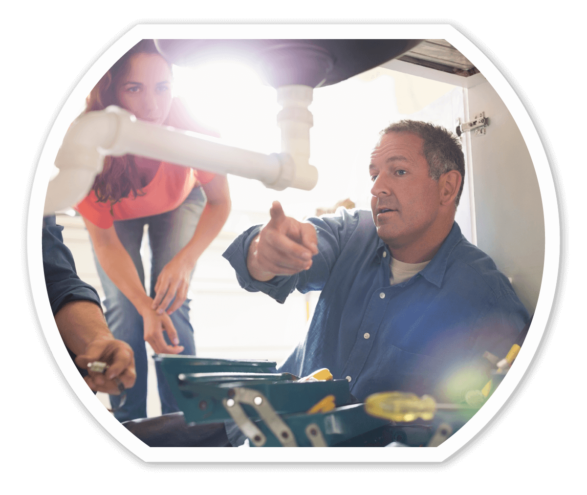 Plumber instructing homeowner on results of an inspection of the kitchen sink.